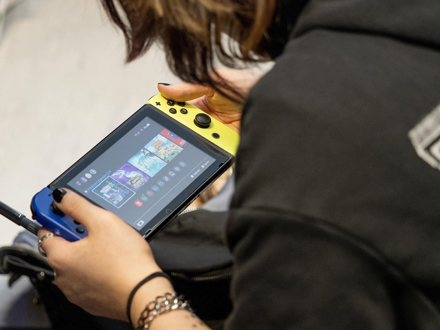 A person playing a game on a handheld console — illustrative photograph.