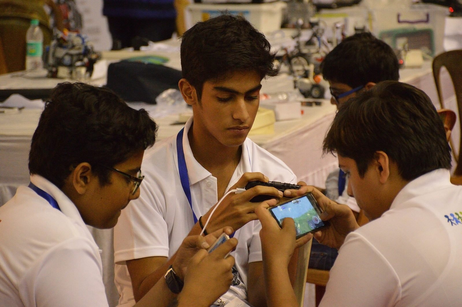 Students playing a mobile game together outdoors — illustrative photograph.