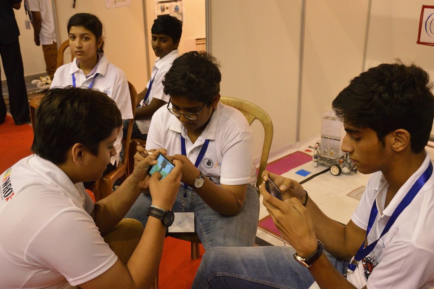 Students gathered around a mobile phone game — illustrative photograph.